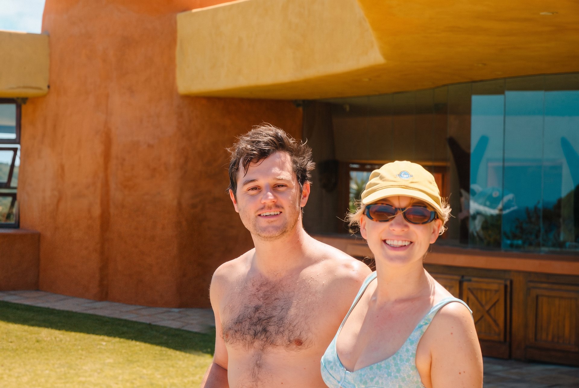Two guests standing together beneath the sand-plastered walls of the villa