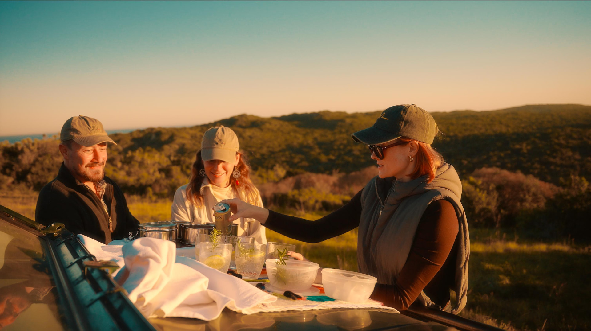 Sundowners served on the bonnet of a game-drive vehicle above the bush